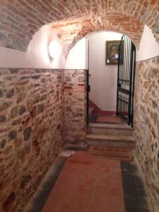 a room with a brick wall and a door with a staircase at A little gem in the old city center... in Lerici