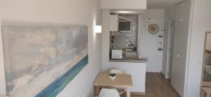 a kitchen with a table and a painting on the wall at Sunny Suites Jupiter Apartments in Benalmádena