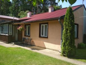 een klein huis met een tafel en stoelen in een tuin bij Zacisze in Supraśl
