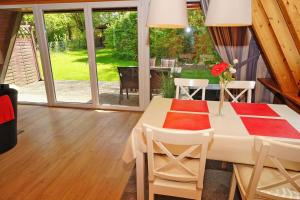 a dining room with a table and a view of a yard at Zeltdachhaus mit moderner Ausstattung in Damp