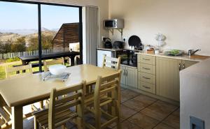 a kitchen with a table and chairs and a large window at ADamsview in Gariepdam