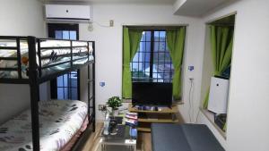 Zimmer mit einem Etagenbett und einem TV in der Unterkunft Comfort CUBE PHOENIX S Kumamoto in Kumamoto