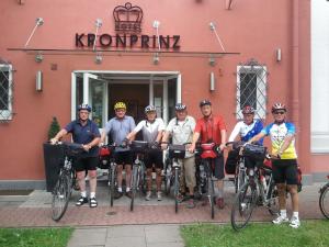 ミンデンにあるHotel Kronprinz Garniの自転車を持って建物の前に立つ人々