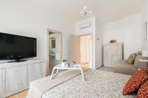 Una sala de estar con un televisor y una mesa. en Stars Luxury Apartments 1, en Roma