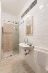 Un baño blanco con lavabo y ducha. en Stars Luxury Apartments 1, en Roma
