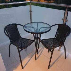 een glazen tafel en 2 stoelen op een balkon bij Apartament Calamo Park in Olsztyn