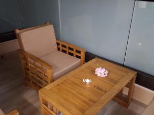 a table and a chair and a wooden table with flowers on it at Guesthouse Laterna in Herceg-Novi