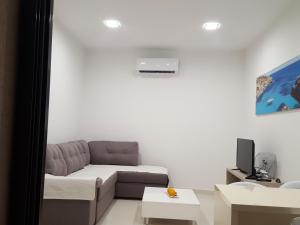 a living room with a couch and a tv at Guesthouse Laterna in Herceg-Novi