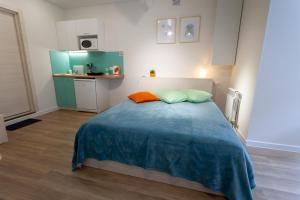 トゥーラにあるКвартира "Александровский парк"のベッドルーム1室(ベッド1台付)、小さなキッチンが備わります。