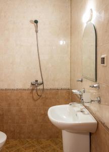 uma casa de banho com um lavatório e um chuveiro em Hotel Milan em Primorsko