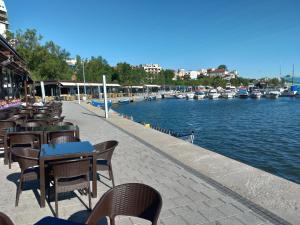 a row of tables and chairs next to a river with boats at Apartament Promenada, 3 camere, max 6 persoane, locatie ideala, 10 min de mers pana la plaja in Constanţa