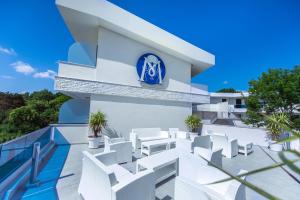un edificio con sillas blancas y un cartel azul en él en Hotel Meduza Estival en Olimp