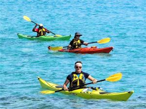 tres personas en kayaks en el océano en el agua en villa Gaby-chambres, en Menton