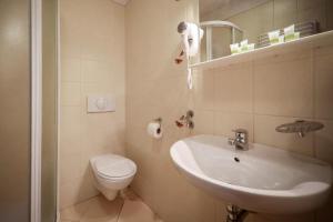a white bathroom with a sink and a toilet at Hotel Pod Jedlami in Wisła +53 photos