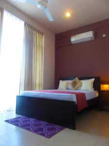 1 dormitorio con 1 cama grande y ventana en VIVAS Residencies Luxury Apartments, en Colombo