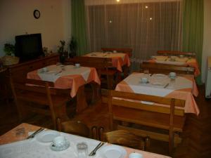 a dining room with four tables and a tv at Guesthouse ROBI in Međugorje