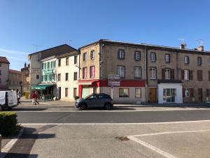 a car parked on a city street with buildings at Chambre privative in Saint-Rémy-sur-Durolle