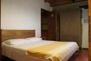 ein Schlafzimmer mit einem großen Bett und einer gelben Decke in der Unterkunft Bassarì in Recanati