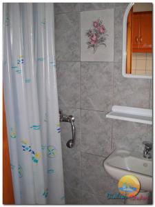 a bathroom with a shower curtain and a sink at DIALEKTI STUDIOS in Toroni