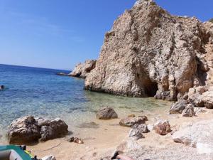 a sandy beach with rocks and the ocean at House Marija island Krk in Punat
