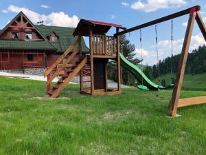 a playground with a slide and a swing at Chata Studnička in Litmanová