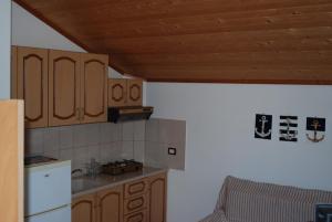 a kitchen with wooden cabinets and a counter top at Apartments Hotel AL&DE in Velipojë