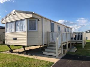 a tiny house with a porch and a staircase at 4 bedroom 10 berth caravans with Hot Tub ,Mountain Bikes Tattershall Lakes in Tattershall