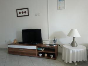 un soggiorno con TV e tavolo con lampada di Apartments Edo a Vis