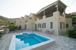 a villa with a swimming pool in front of a house at Hotel Omirikon in Vathi