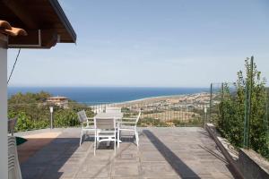 a table and chairs on a patio with a view of the ocean at B&B Le Rose del Tirreno in Falerna