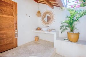 a room with a mirror and a potted plant at Mule Malu Tropical Stay in Uluwatu
