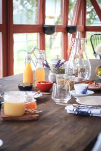 a wooden table with food and bottles of orange juice at SOEDER Countryhouse & Kitchen in Båstad