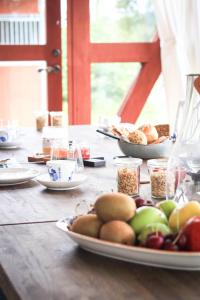 a wooden table with plates of food on it at SOEDER Countryhouse & Kitchen in Båstad