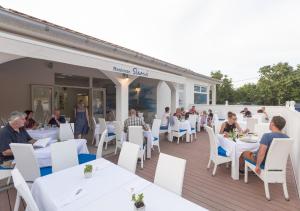 a group of people sitting at tables on a patio at Krk Mobile Homes in Klimno