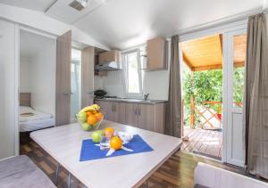 a kitchen with a table with a bowl of fruit on it at Krk Mobile Homes in Klimno