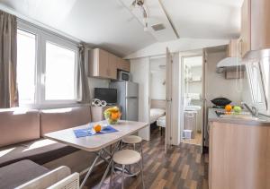 a small kitchen with a table in a small apartment at Krk Mobile Homes in Klimno