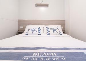 a bedroom with a bed with blue and white pillows at Krk Mobile Homes in Klimno