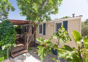 a tiny house with a porch and trees at Krk Mobile Homes in Klimno