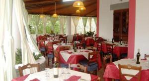 un restaurante con mesas y sillas con manteles rojos y blancos en Agriturismo Galletta, en Leni