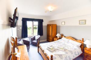 1 dormitorio con 1 cama y sala de estar en Herrislea House Hotel en Tingwall