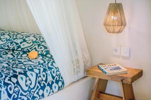 a bedroom with a bed with a book on a table at Mule Malu Tropical Stay in Uluwatu