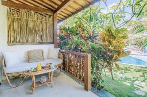 a porch with a white couch and a table at Mule Malu Tropical Stay in Uluwatu