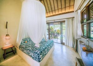 a bedroom with a bed with a canopy at Mule Malu Tropical Stay in Uluwatu