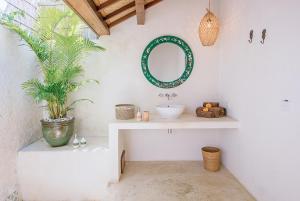 a bathroom with a sink and a mirror on the wall at Mule Malu Tropical Stay in Uluwatu