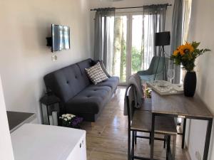 a living room with a couch and a table at Powidz pokoje z widokiem na jezioro in Powidz
