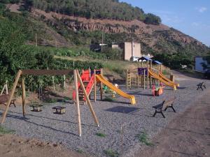 um parque infantil com um monte de equipamento de brincar numa colina em Agriturismo Galletta em Leni