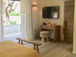 a bedroom with a desk and a television on a wall at villa Sant-Anna in Saint-Tropez