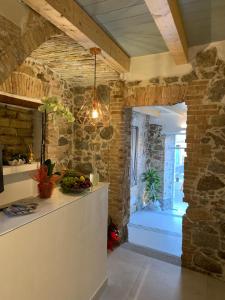 a kitchen with a counter and a stone wall at PERDAS ROOMS in Villasimius