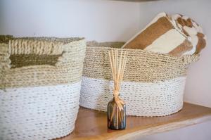 two baskets sitting on a wooden shelf with a vase at Mule Malu Tropical Stay in Uluwatu