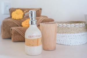 a bottle of hand sanitizer next to a holder at Mule Malu Tropical Stay in Uluwatu